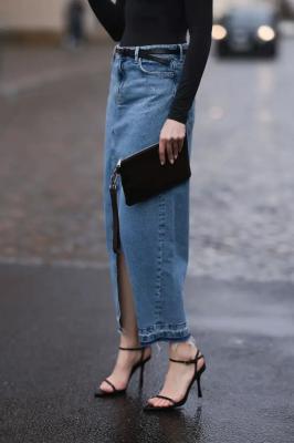 Девушка в джинсовой юбке и минималистичных черных босоножках с ремешками