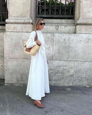Девушка в белом романтичном платье макси с поясом и с соломенной сумкой