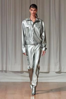 Модель в серебристых брюках, куртке и ботильонах