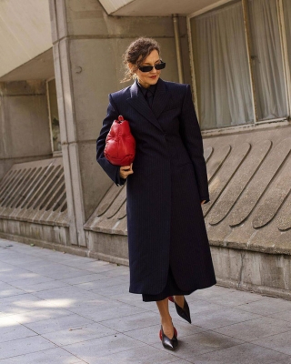 Женщина в черном классическом пальто и туфлях с острым носом