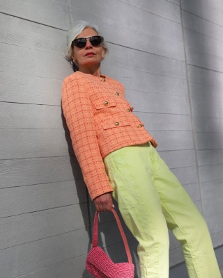 Женщина в светлых брюках и персиковом твидовом жакете
