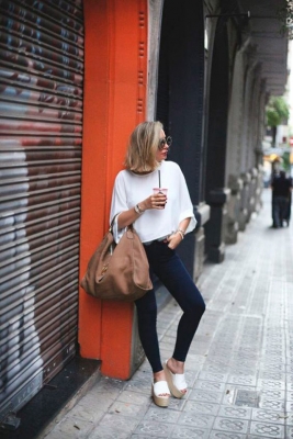 Девушка в облегающих джинсах, простая белая офта и сандалии на платформе