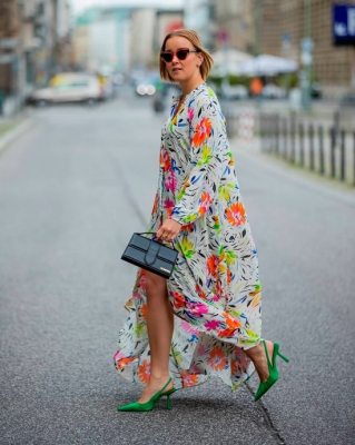 Девушка в свободном макси платье с ярким цветочным принтом, образ дополняют зеленые остроконечные туфли с открытой пяткой и сумочка