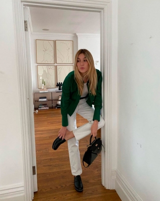 Девушка в прямых белых джинсах с ремнем и зеленом бомбере