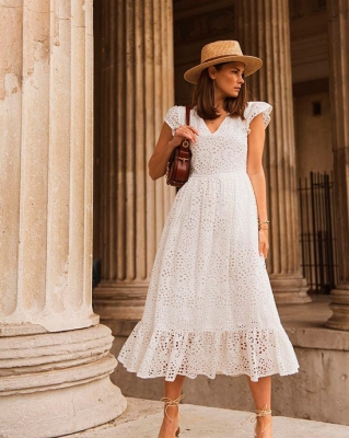 Девушка в романтическом белом платье миди с короткими рукавами, образ дополняет соломенная шляпа и коричневая сумочка